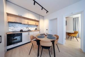 a kitchen with a table and chairs in a room at Grand Chalet 10 Poiana Brașov in Poiana Brasov