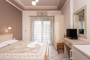 a bedroom with a bed and a television in a room at Katerina Rooms & Apartments in Skala Potamias