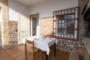 a dining room with a white table and chairs at Villa Angela in Sant'Isidoro +23 photos