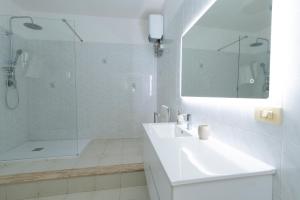 a white bathroom with a sink and a shower at Villa Angela in Sant'Isidoro