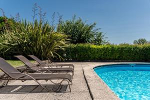 a group of chairs sitting next to a swimming pool at Casa do Lagar in Cabeceiras de Basto +97 photos
