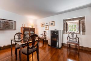 a dining room with a table and chairs and a refrigerator at Casa do Lagar in Cabeceiras de Basto