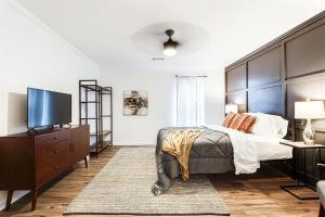 a bedroom with a large bed and a flat screen tv at Scandi Chic-mins to KSU, Sleeps 5, wKing, pet friendly in Kennesaw