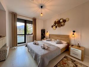 a bedroom with a bed and a large window at Apartament Alma in Sinaia