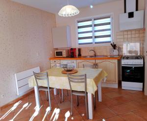 una cucina con un tavolo e sedie in una stanza di Au petit lieu-dit a Anglade