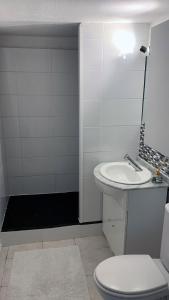 une salle de bain blanche avec un lavabo et des toilettes dans l'établissement Maison de plein pied à Barcares, au Barcarès