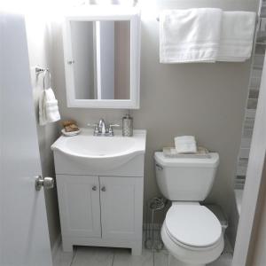 a white bathroom with a toilet and a sink at Exclusive Apt in Shaw in Washington, D.C. +13 photos