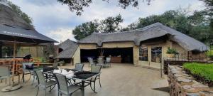 eine Terrasse mit Stühlen und Tischen und ein Gebäude in der Unterkunft Tidimalo Lodge in Rustenburg