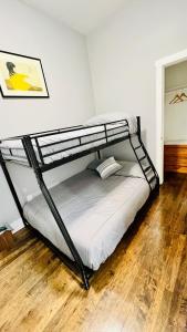 Ce lit superposé noir se trouve dans un dortoir doté de parquet. dans l'établissement Modern Pilsen Chicago Apartment 2 bedroom, à Chicago