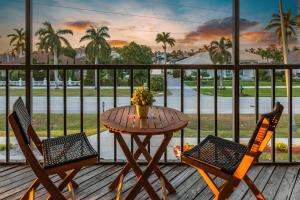 a table and two chairs on a deck with a view of the street at Casa Marco - Heated Pool, Game Room, Mini Golf in Marco Island +45 photos