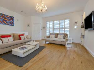 a living room with two couches and a chandelier at 10 Cove View in Ilfracombe