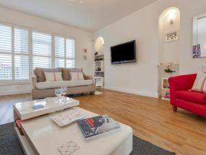 a living room with a couch and a red chair at 10 Cove View in Ilfracombe