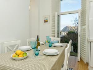 a dining room with a table with a bowl of fruit at 10 Cove View in Ilfracombe