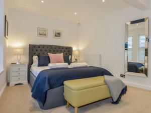 a bedroom with a large bed and a yellow bench at 10 Cove View in Ilfracombe