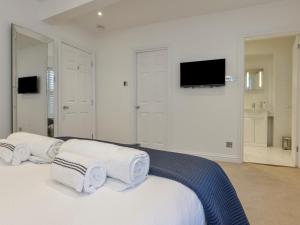 a white bedroom with white towels on a bed at 10 Cove View in Ilfracombe