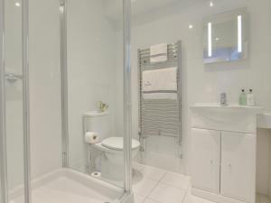 a white bathroom with a toilet and a sink at 10 Cove View in Ilfracombe
