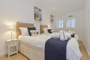 a bedroom with two beds and a table with a lamp at 10 Cove View in Ilfracombe