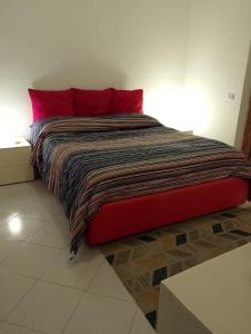 a bed with red pillows in a room at MareBlu in Acireale