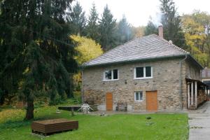 een stenen huis met een bankje ervoor bij Harangvirag 36 Apartman in Kismaros