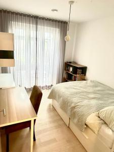 a bedroom with a bed and a desk and a window at Eastside Stay in Frankfurt