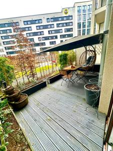 a wooden deck with a table and chairs on a balcony at Eastside Stay in Frankfurt