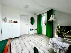 a living room with green curtains and a table at Sala Gracja in Zambrów