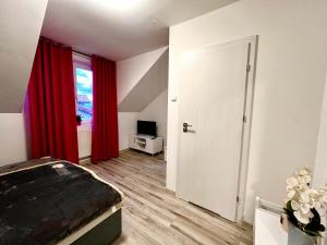 a room with a bed and a window with red curtains at Sala Gracja in Zambrów