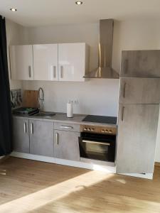 a kitchen with white cabinets and a stove top oven at Ferienhof Schnieder in Dülmen