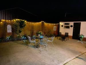a patio with a table and chairs at night at Paddock View - Snetterton Norfolk in Norwich +25 photos