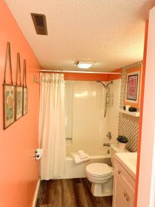 a bathroom with a toilet and a tub and a sink at Daylight Cove Lakefront Condo, Pool, Hot Tub! in Lake Ozark