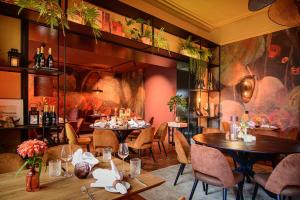 ein Restaurant mit Tischen und Stühlen und einem Wandgemälde in der Unterkunft Hotel Schepers in Gronau
