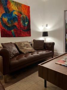 a living room with a brown couch and a painting at East Durham Terraced Home in Easington