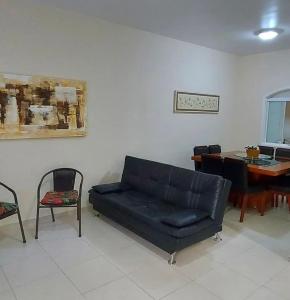 ein Wohnzimmer mit Sofa und Tisch in der Unterkunft Hospedaria Litoral in Caraguatatuba