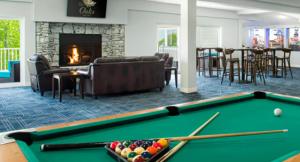 a living room with a pool table and a fireplace at Partee Bungalow at Margaritaville in Osage Beach