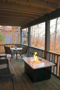 a fire pit on a deck with a table and chairs at Partee Bungalow At Margaritaville in Osage Beach