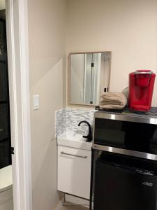 a small kitchen with a sink and a microwave at Studio unit with private entrance, 2 bed 1 bath in St. John's