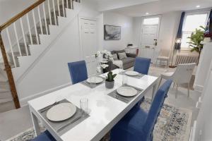 una sala da pranzo con un tavolo bianco e sedie blu di Georgetown Cobblestone Cottage - Private Parking a Washington Altre 12 foto