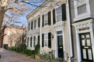 una casa bianca con finestre nere su una strada di Georgetown Cobblestone Cottage - Private Parking a Washington