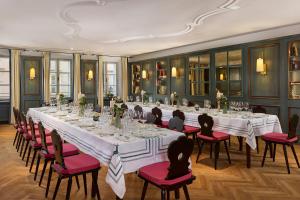 a large room with a long table with red chairs at Hotel Goldener Hirsch, A Luxury Collection Hotel, Salzburg in Salzburg