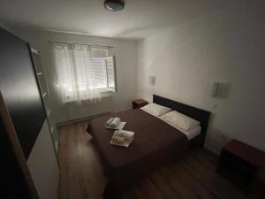a small bedroom with a bed and a window at Apartman Jelena 1 in Biograd na Moru +6 photos