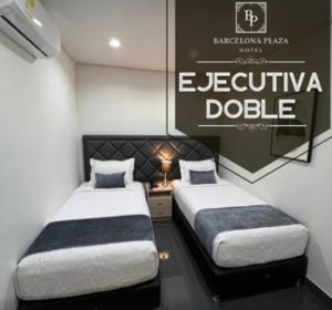 two beds in a room with a sign on the wall at HOTEL BARCELONA PLAZA galapa in Galapa