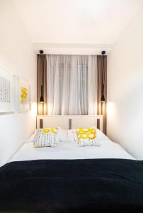 a bedroom with a white bed with yellow and white pillows at Geri Natur Home in Zalaegerszeg