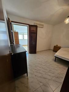 a room with a bedroom with a bed and a table at Domu Asquer 9 in Fluminimaggiore