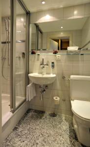 a bathroom with a sink, toilet and bathtub at Hotel Blumenstein Self-Check In in Frauenfeld