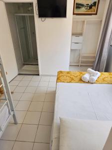 a room with a bed and towels on a counter at Pousada Rota do Sol in Cabo Frio
