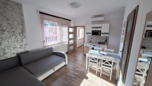 a living room with a couch and a table at Dream Lux Apartman in Hajdúszoboszló