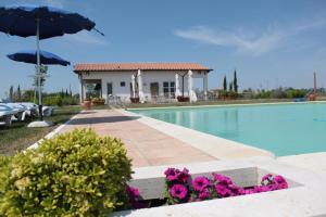 a villa with a swimming pool and a house at Residenza Principina in Principina Terra