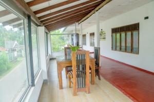 a dining room with a table and some windows at Sunshine Hotel in Hikkaduwa