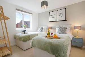 a bedroom with two beds with a tray of fruit on it at Detached House in Brooklands - Prime Location - Driveway Parking, Self-Check-In, Fast WiFi and Smart TV by Yoko Property in Milton Keynes