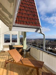 Una terraza en el tejado con un banco y una mesa en Villa Aussicht, en Freudenstadt